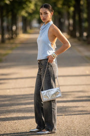 Blusa de cuello halter fluido, escote en espalda con lazo amarrable posterior, cierre con botón y ojal.