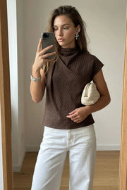 Blusa de estampado rayas, cuello alto fluido, plisados en hombros, manga corta seguida y fit recto. Cierre posterior con botón y ojal.