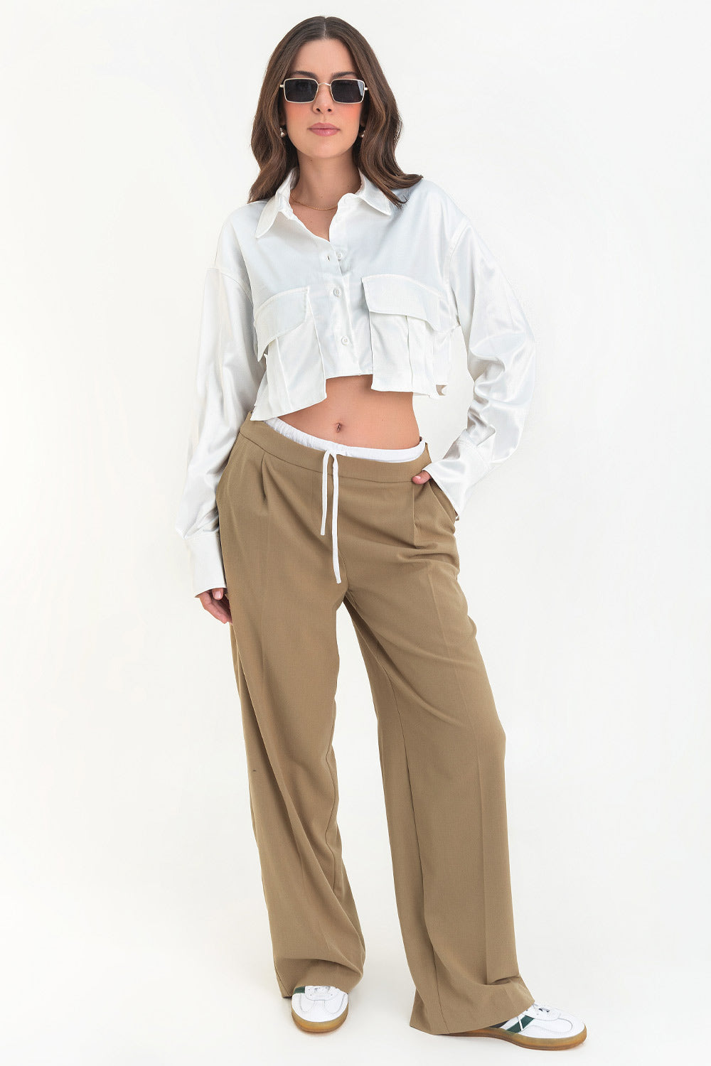 Camisa corta satinada de manga larga con puño abotonado, cuello camisero, fit ligeramente oversized, bolsillos frontales cargo con cartera y cierre frontal con hilera de botones.