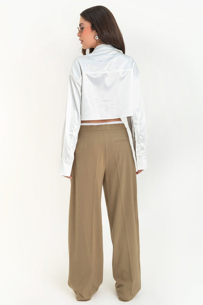 Camisa corta satinada de manga larga con puño abotonado, cuello camisero, fit ligeramente oversized, bolsillos frontales cargo con cartera y cierre frontal con hilera de botones.