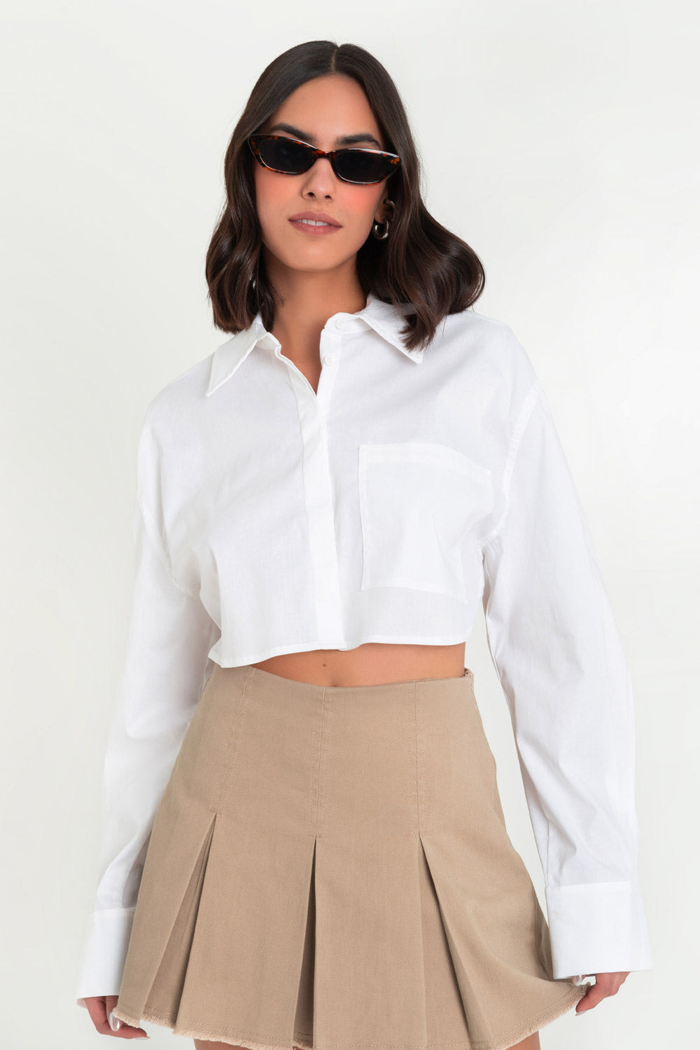 Camisa corta de manga larga con puño abotonado, fit oversized, cuello camisero, bolsillo delantero de parche, bajo curveado y cierre frontal con hilera de botones. Detalle de cut out en espalda con talle cruzado.