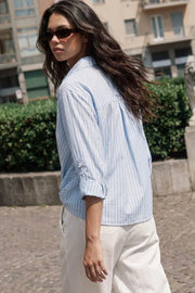 Camisa corta de estampado rayas, fit recto, manga larga rolled up con trabilla ajustable, cuello camisero, cruce frontal con escote v y nudo decorativo en bajo. Detalle de bajo curveado y pinza de amplitud en espalda.