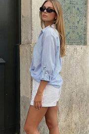 Camisa corta de estampado rayas, fit recto, manga larga rolled up con trabilla ajustable, cuello camisero, cruce frontal con escote v y nudo decorativo en bajo. Detalle de bajo curveado y pinza de amplitud en espalda.