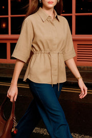 Camisa de fit oversized, manga 3/4 amplia con doblez en puños, cuello camisero y jareta ajustable en cintura. Cierre frontal con hilera oculta de botones.