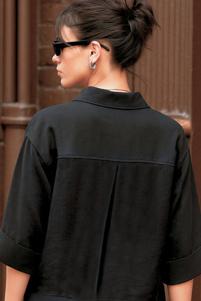 Camisa corta de estilo utilitario. Corte recto, silueta amplia y largo crop. Frente con cuello camisero clásico, tapeta de botones y dos bolsillos con tapa en el pecho. Espalda con canesú y tablón central invertido.