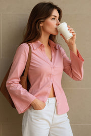 Camisa de fit ajustado, cuello camisero, manga larga amplia con botones, pinzas, bajo curveado y cierre frontal con hilera de botones.