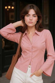 Camisa de fit ajustado, cuello camisero, manga larga amplia con botones, pinzas, bajo curveado y cierre frontal con hilera de botones.