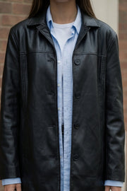 Blazer de efecto piel, fit ligeramente oversized, con solapa y hombreras, manga larga con puño abotonado, costuras decorativas y bolsillos delanteros con vivos. Detalle de abertura posterior en bajo y cierre frontal con hilera de botones.