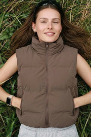 Chaleco corto puffer de fit recto, cuello solapa alto, bolsillos delanteros, bolsillos delanteros y cierre frontal con cremallera.