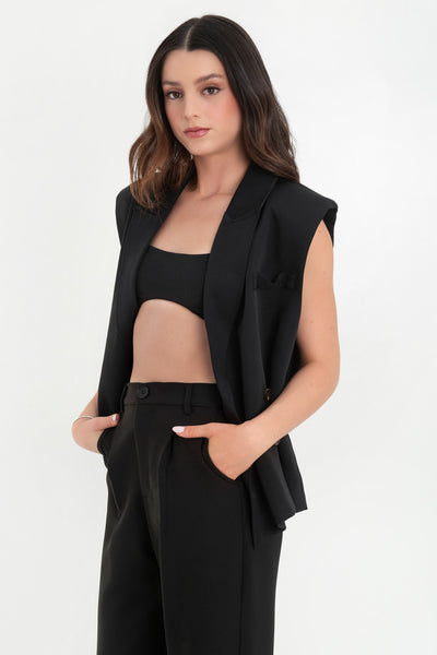 Chaleco cruzado de fit oversized, con hombreras y solapa, bolsillos delanteros con cartera y vivo decorativo frontal. Cierre con cruce de botones.