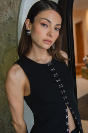 Chaleco de fit recto, cuello redondo y cierre frontal con hilera de broches en contraste.