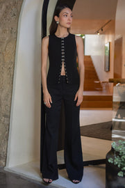 Chaleco de fit recto, cuello redondo y cierre frontal con hilera de broches en contraste.