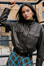 Chamarra de efecto piel, fit oversized, manga larga con puño abotonado, cuello alto, bolsillos delanteros con cartera, cortes decorativos y pretina elástica. Cierre frontal con cremallera oculta.