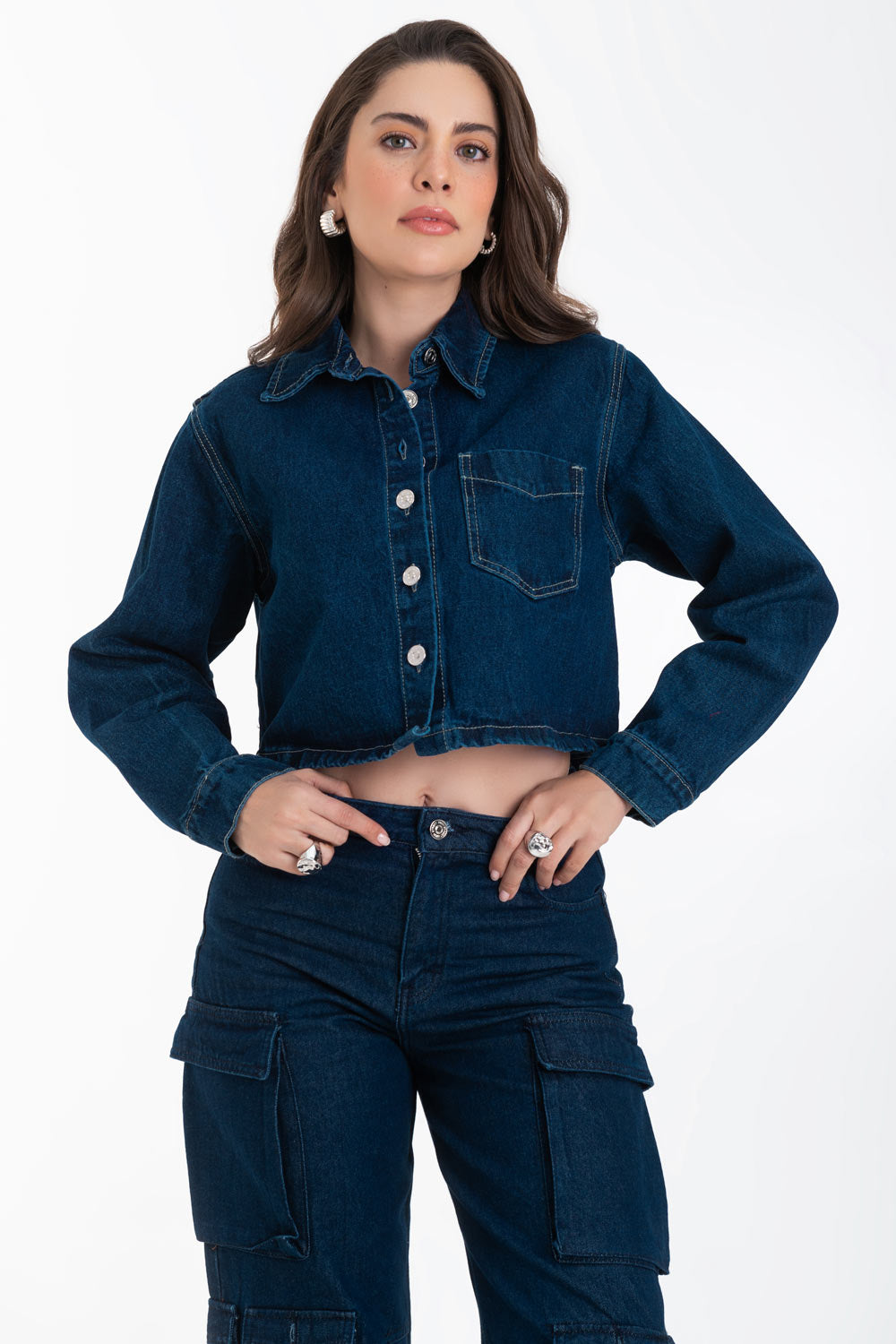 Chamarra corta de denim, fit recto, manga larga con puño abotonado, bolsillo frontal de parche, cuello camisero, detalle de costuras en contraste y cierre frontal con hilera de botones.