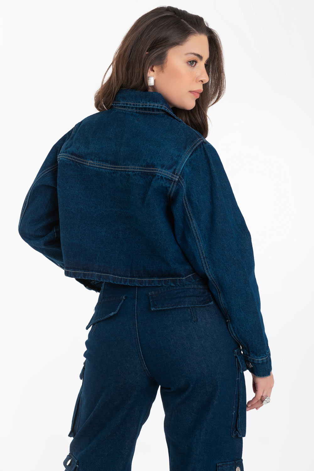 Chamarra corta de denim, fit recto, manga larga con puño abotonado, bolsillo frontal de parche, cuello camisero, detalle de costuras en contraste y cierre frontal con hilera de botones.