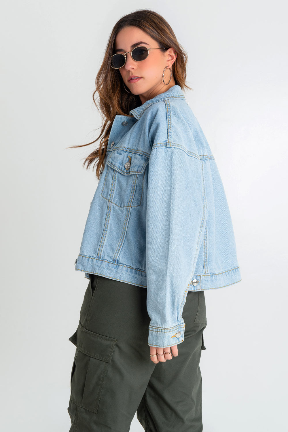 Chamarra de denim, fit ligeramente oversized, manga larga con puños abotonados, cuello clásico, bolsillos delanteros, frontales con cartera y botón en contraste. Cierre frontal con hilera de botones en contraste.