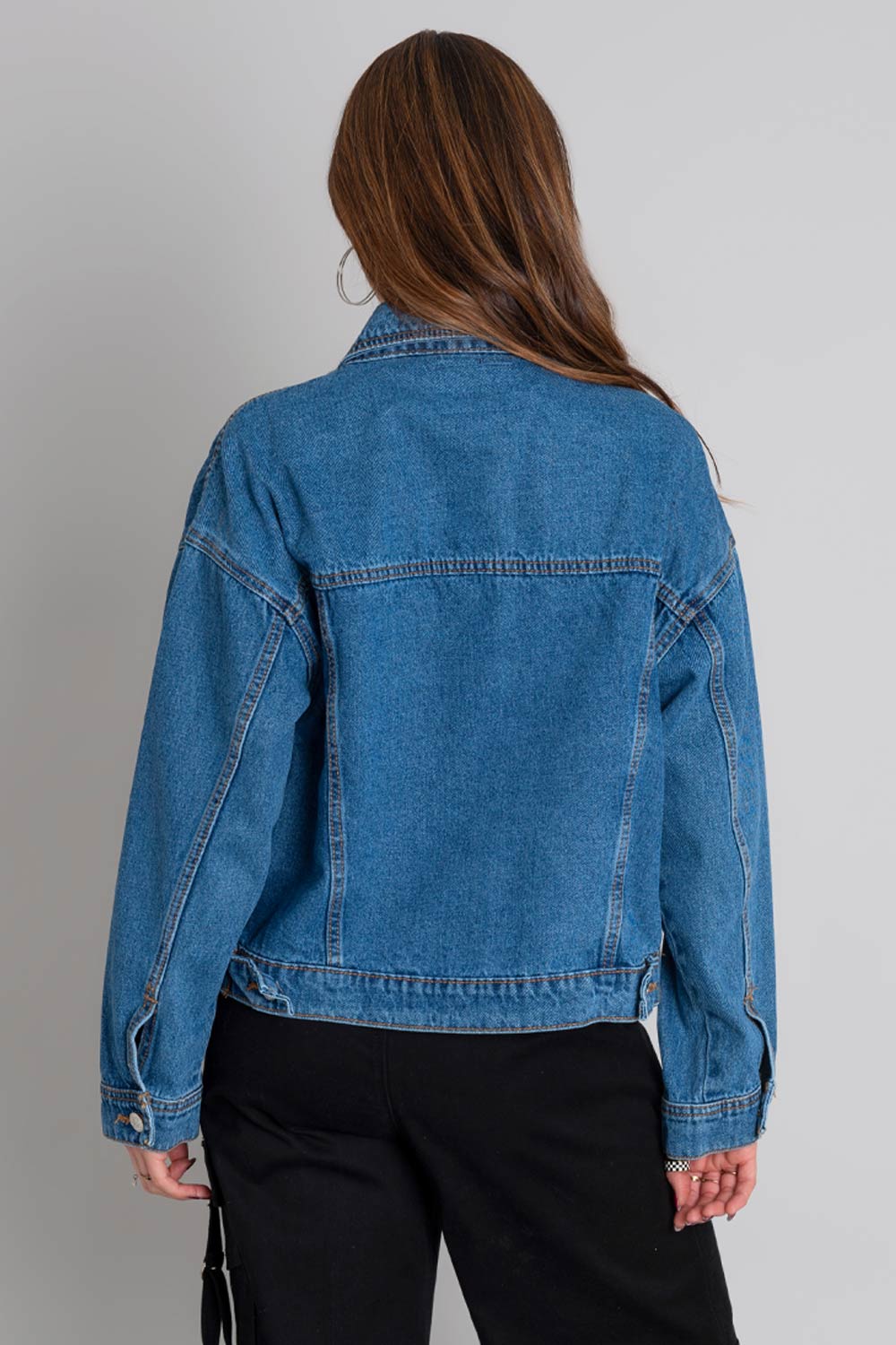 Chamarra de denim, fit ligeramente oversized, manga larga con puños abotonados, cuello clásico, bolsillos delanteros, frontales con cartera y botón en contraste. Cierre frontal con hilera de botones en contraste.