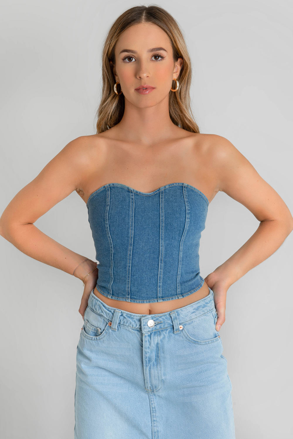 Corset de denim en lavado medio, escote corazón, fit ajustado, costuras decorativas frontales y cierre posterior con cremallera visible en contraste