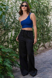 Crop top asimétrico de un hombro, fit ajustado y cierre de cremallera visible posterior.
