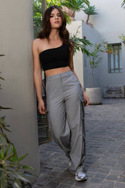 Crop top asimétrico de un hombro, fit ajustado y cierre de cremallera visible posterior.