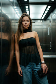 Crop top strapless de mesh, fit ajustado, escote recto con detalles plisados laterales, bajo asimétrico con olanes y rib rizado en borde. Detalle de choker.