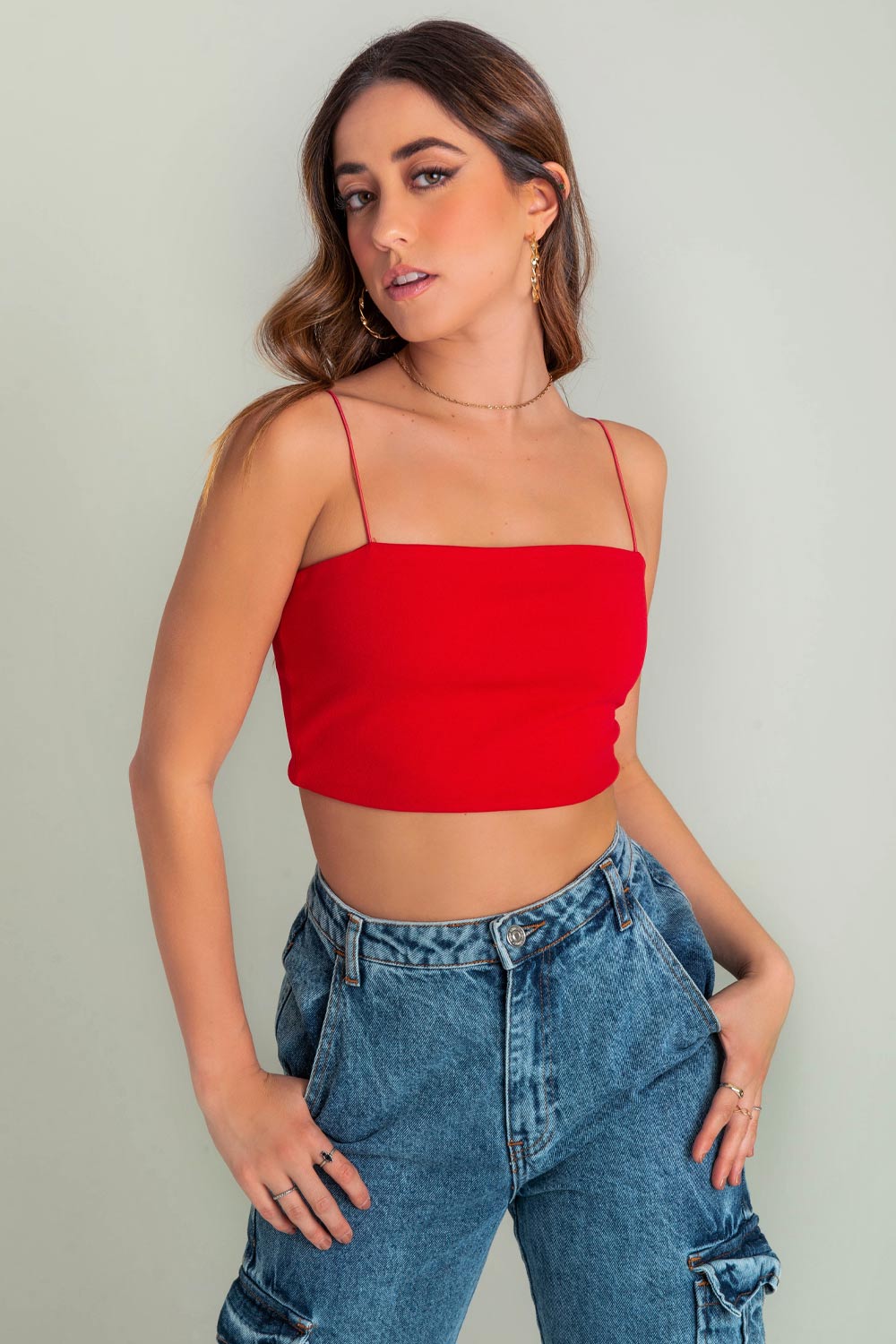 Crop top bandeau de fit ajustado, escote recto y tirantes delgados elásticos. Cierre posterior con cremallera visible.