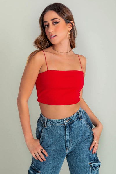 Crop top bandeau de fit ajustado, escote recto y tirantes delgados elásticos. Cierre posterior con cremallera visible.