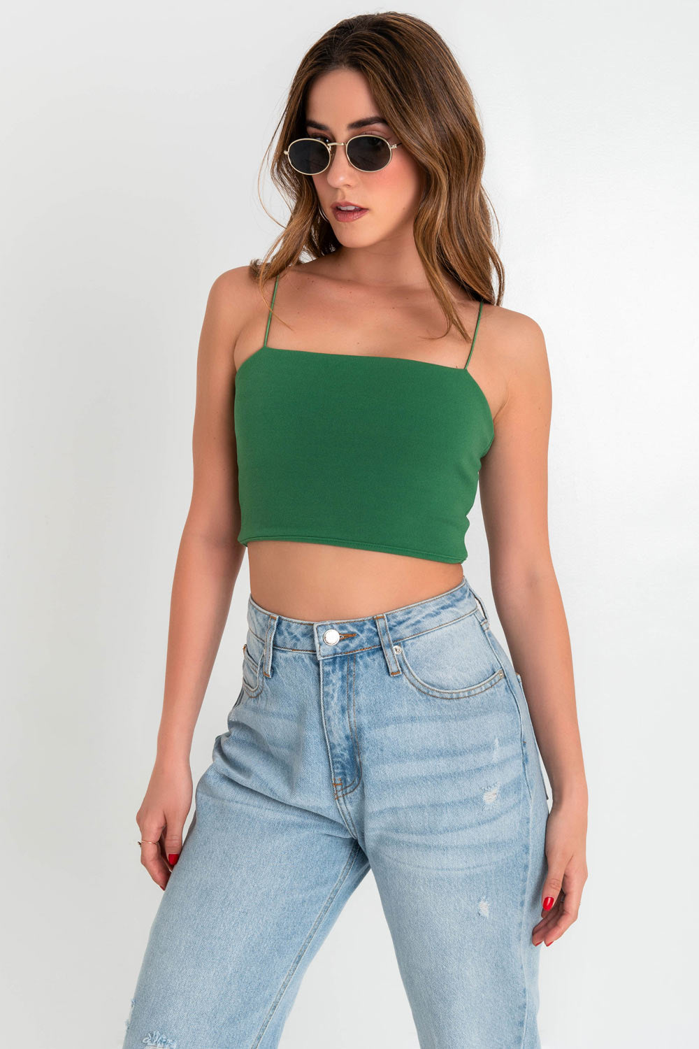 Crop top bandeau de fit ajustado, escote recto y tirantes delgados elásticos. Cierre posterior con cremallera visible.