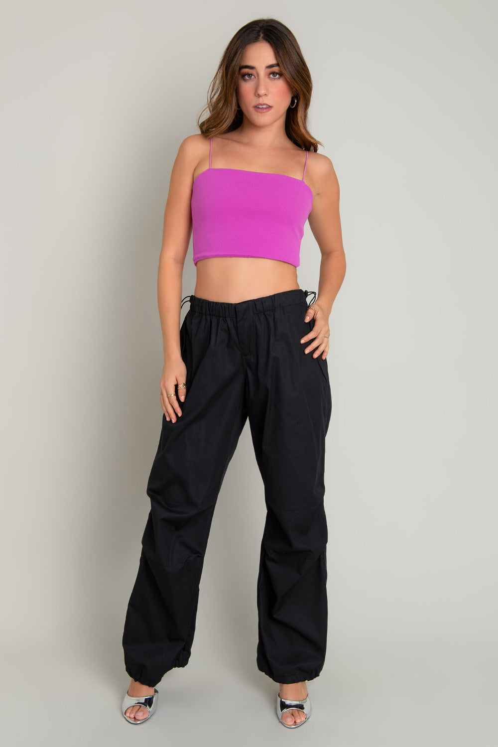 Crop top bandeau de fit ajustado, escote recto y tirantes delgados elásticos. Cierre posterior con cremallera visible.