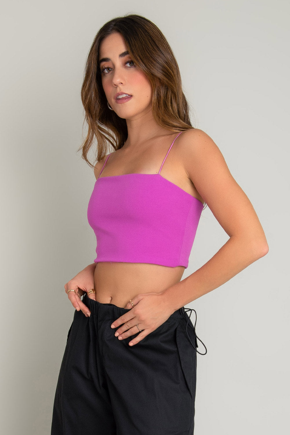 Crop top bandeau de fit ajustado, escote recto y tirantes delgados elásticos. Cierre posterior con cremallera visible.