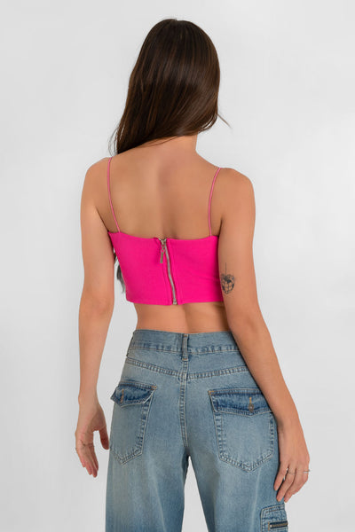 Crop top bandeau de fit ajustado, escote recto y tirantes delgados elásticos. Cierre posterior con cremallera visible.