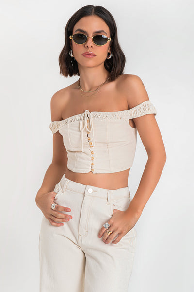 Crop top de lino, fit ajustado, hombros descubiertos, escote con plisados decorativos en borde y jareta frontal ajustable, tirantes plisados, costuras decorativas frontales y cierre posterior con cremallera visible en contraste.