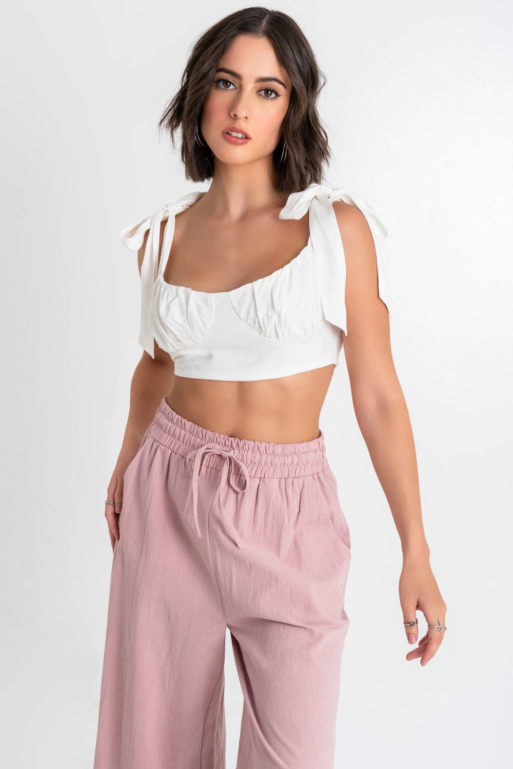 Crop top de lino, fit ajustado, escote redondo con detalles plisados, cortes decorativos frontales, tirantes con nudo amarrable y cierre con lazo amarrable posterior.