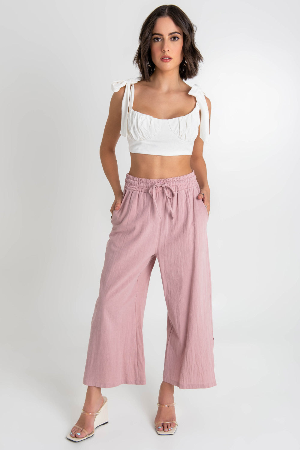 Crop top de lino, fit ajustado, escote redondo con detalles plisados, cortes decorativos frontales, tirantes con nudo amarrable y cierre con lazo amarrable posterior.