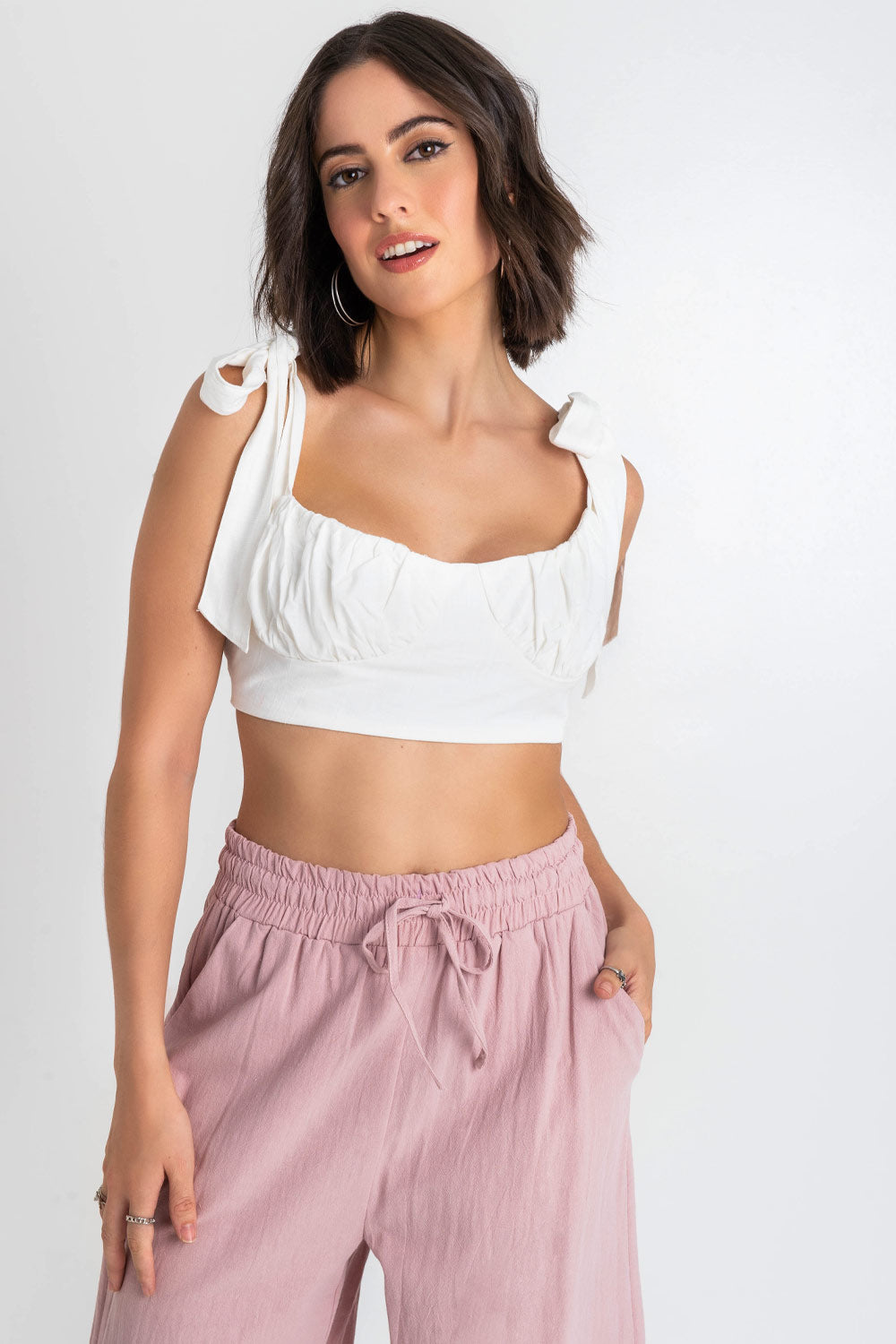 Crop top de lino, fit ajustado, escote redondo con detalles plisados, cortes decorativos frontales, tirantes con nudo amarrable y cierre con lazo amarrable posterior.