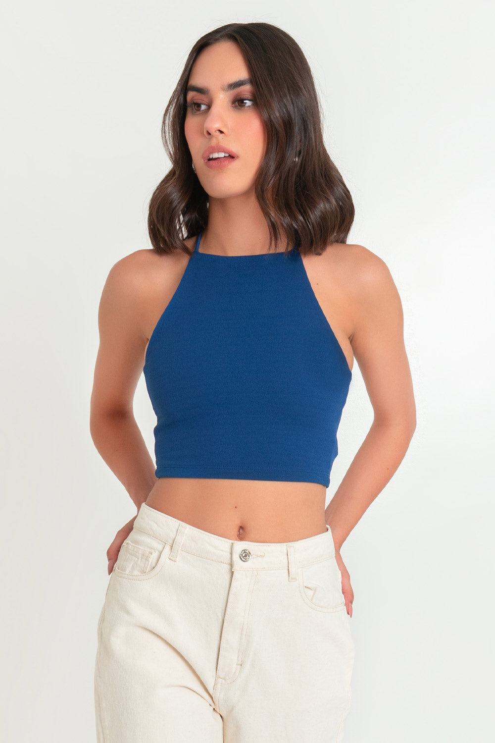 Crop top de fit ajustado, cuello halter con tirantes delgados cruzados, escote en espalda y jareta ajustable posterior.