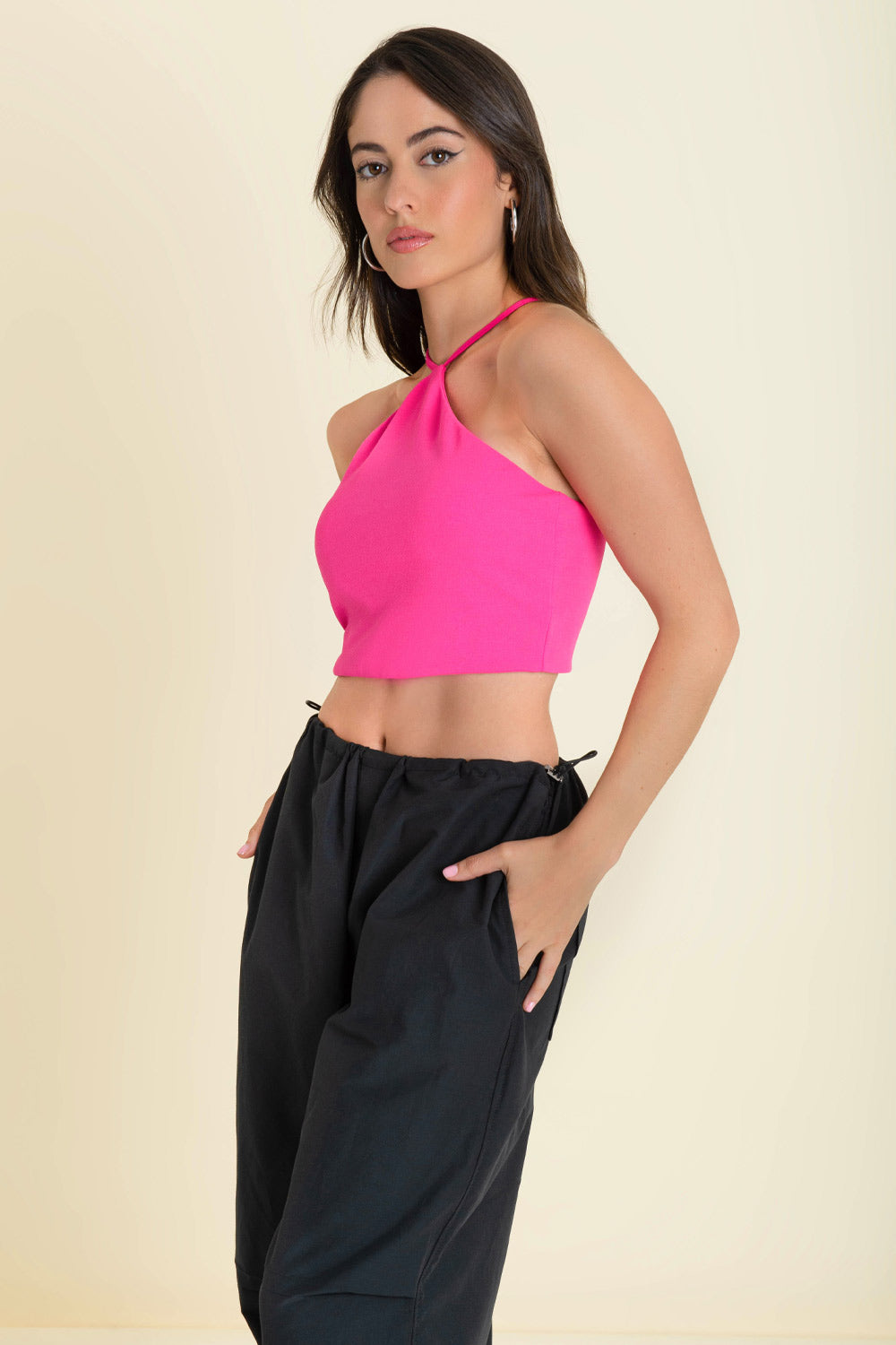 Crop top de cuello halter con tirantes delgados ajustables, fit ajustado y cierre posterior con cremallera visible en contraste.