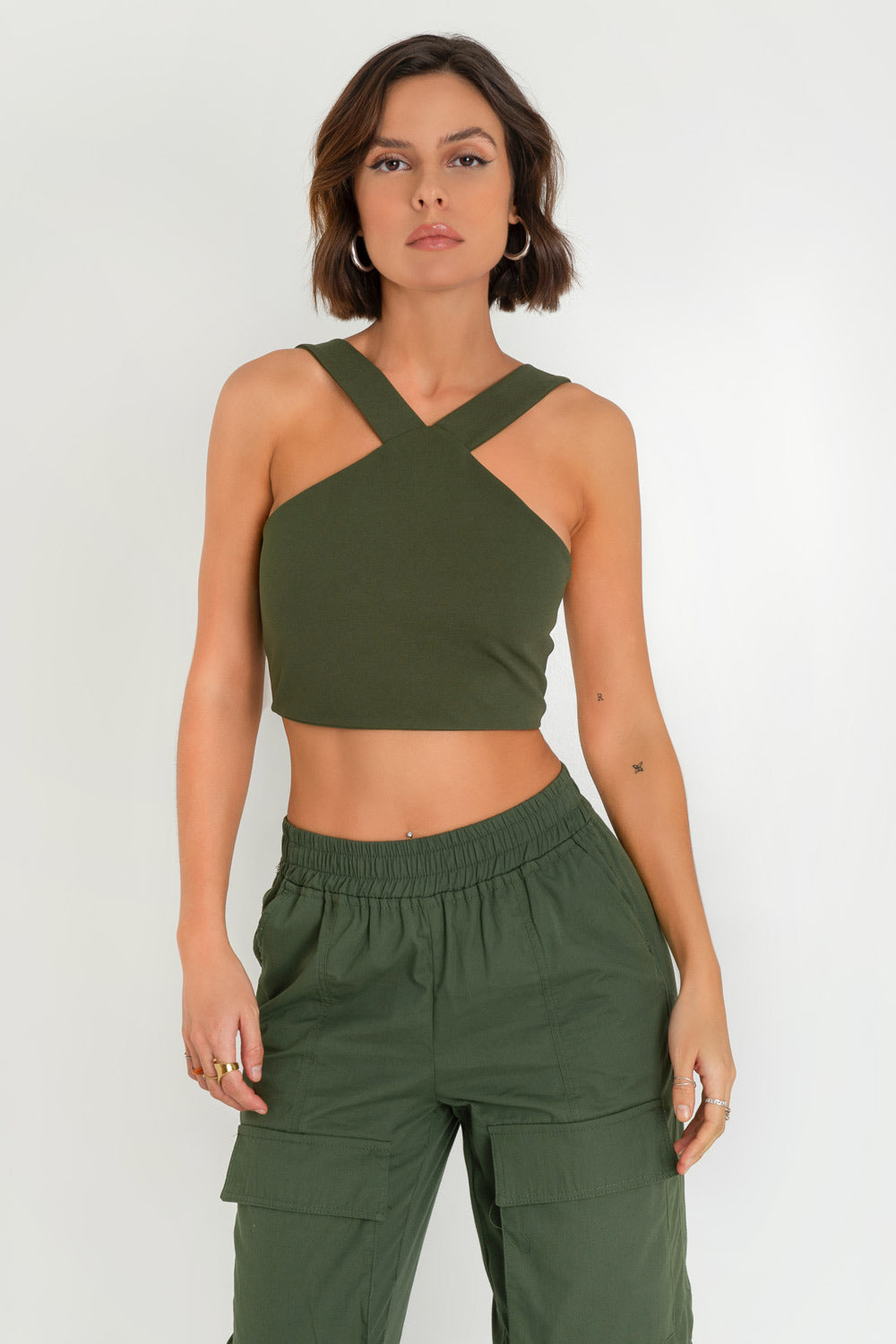 Crop top de cuello halter v con tirantes, fit ajustado y cierre posterior con cremallera visible en contraste.