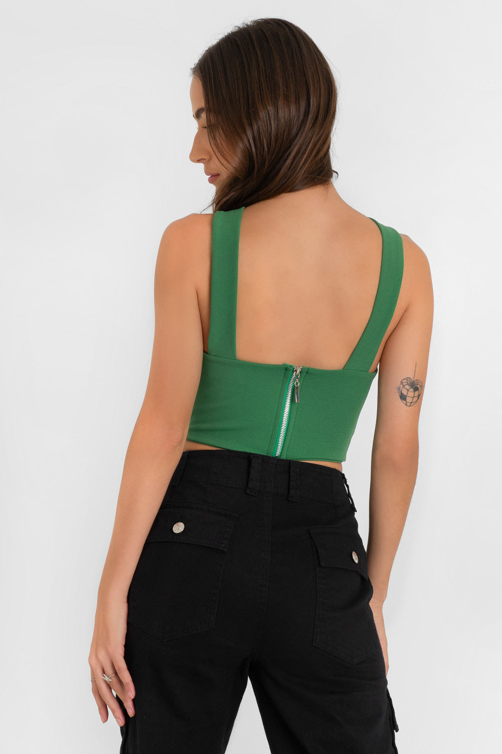 Crop top de cuello halter v con tirantes, fit ajustado y cierre posterior con cremallera visible en contraste.