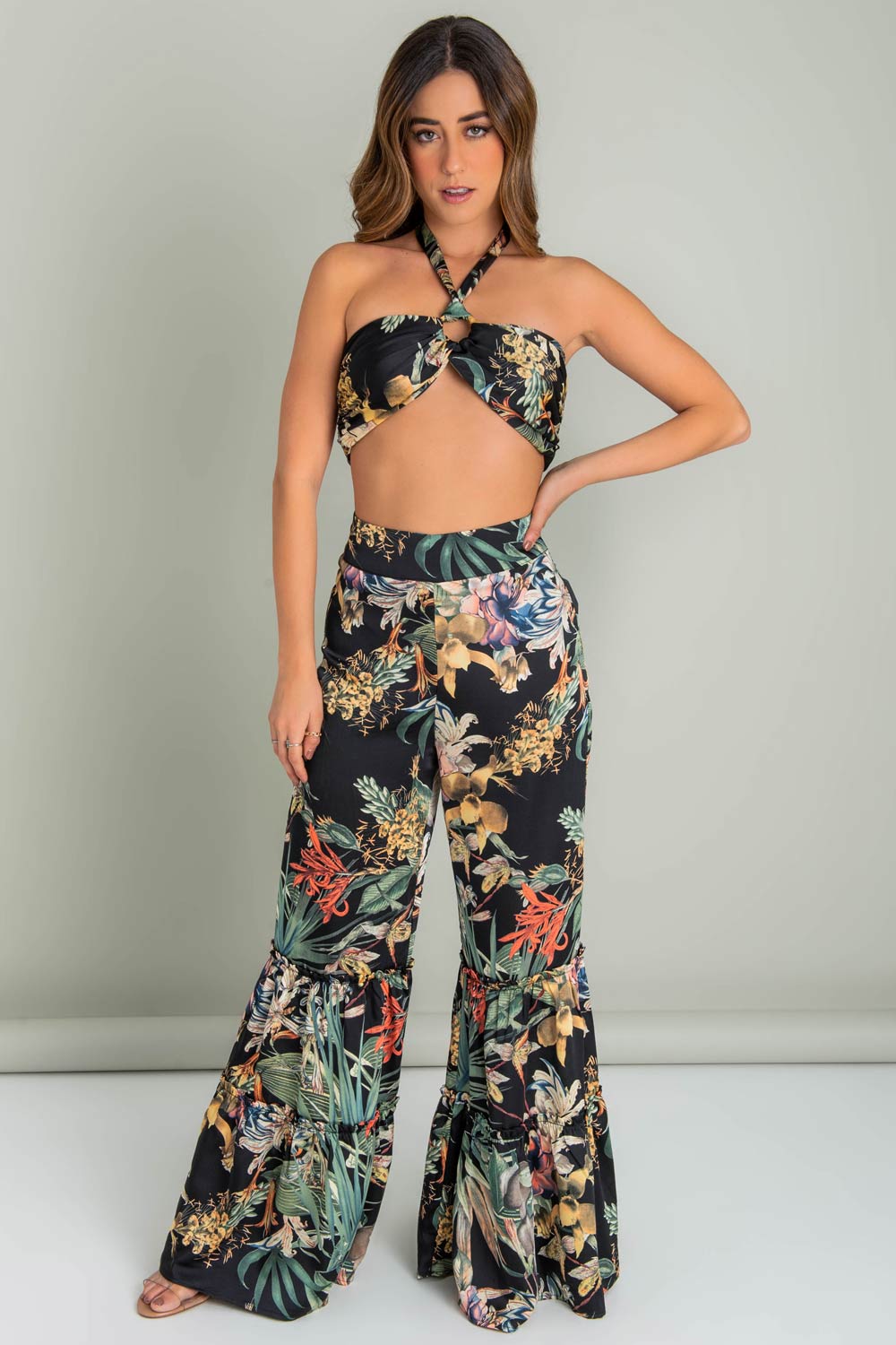 Crop top de estampado tropical, cuello halter con lazo amarrable posterior, cut out frontal con argolla, detalles plisados frontales y cierre con lazo amarrable posterior.