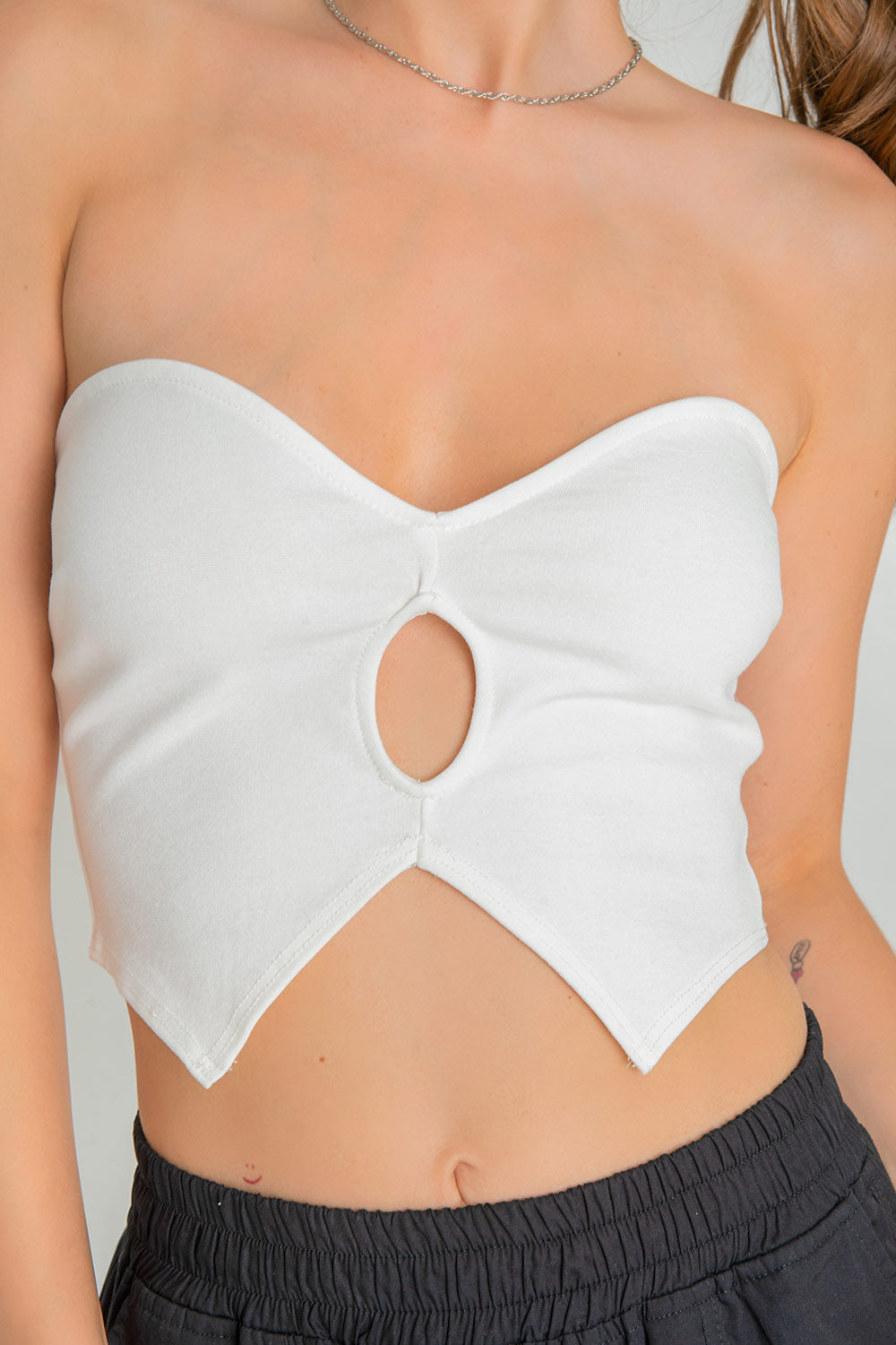 Crop top tubo de fit ajustado, escote corazón, cut out frontal y bajo con detalles en pico.