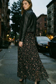 Falda maxi de estampado floral, corte en a, cintura alta con detalle plisados y olanes en bajo. Cierre lateral con cremallera oculta.