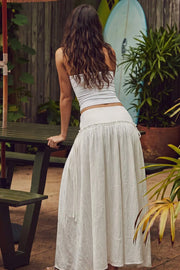 Falda midi de corte en a, cintura baja, corte en cadera con plisados y lazos laterales decorativos. Cierre lateral con cremallera oculta.
