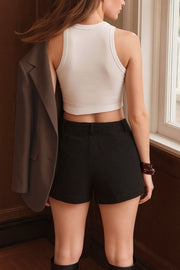 Falda short corto de fit ajustado, cintura alta con pretina y trabillas, bolsillos delanteros, cierre frontal con botón y cremallera oculta.