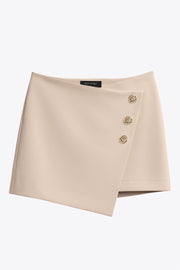 Falda short corto de fit ajustado, cintura alta, cruce frontal con nudo y plisados decorativos frontales. Cierre posterior con cremallera oculta.