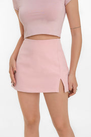 Falda short corta básica de cintura alta, corte en a, abertura frontal en bajo y cierre lateral con cremallera oculta.