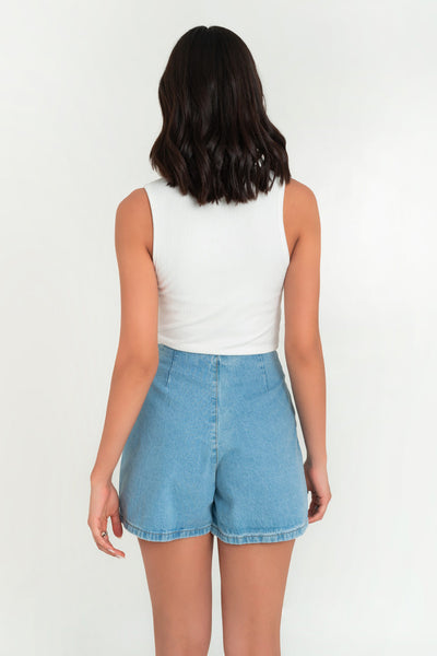 Falda short corto cruzado de denim, corte en a, cintura alta, cortes decorativos con abertura y cierre frontal con botón en contraste.