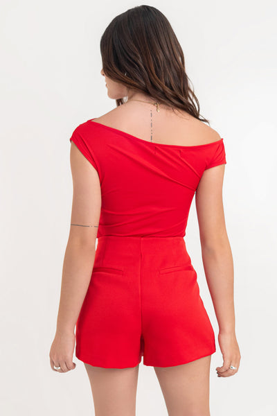 Falda short corto de fit ajustado, cintura alta, cruce frontal con bajo asimétrico, vivos decorativos posterior y cierre lateral con cremallera oculta.
