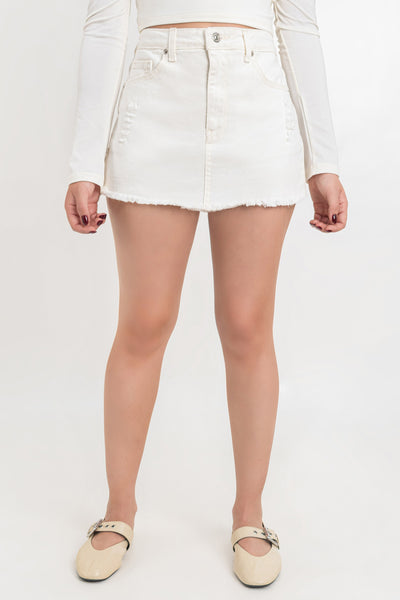 Falda short corto de denim, fit recto , cintura alta con pretina, trabillas, bolsillos delanteros y traseros de parche. Detalle de rotos en bajo, cierre frontal con cremallera oculta y botón en contraste.