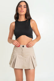 Falda short corto cargo, de cintura alta con pretina, corte en a, bolsillos laterales cargo con cartera, tableado frontal y posterior. Cierre frontal con botón en contraste y cremallera oculta.